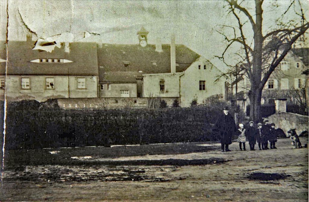 Blick vom Dorfplatz in Richtung Schloß, Bogenbrücke; Pächterwohnungen mit Turmuhr welche später auf die Schule gebaut wurde nach 1927